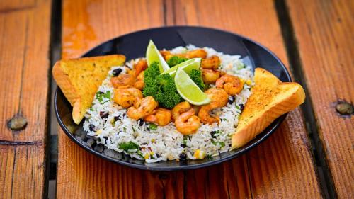 a plate of food with shrimp and rice and toast at Genas's Sierra Inn & Restaurant in Dunlap