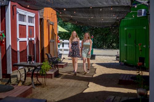 two women walking down a street under a tent at Genas's Sierra Inn & Restaurant in Dunlap