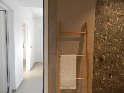 a bathroom with a towel rack and a wall at Bel Air Rooms in Himare
