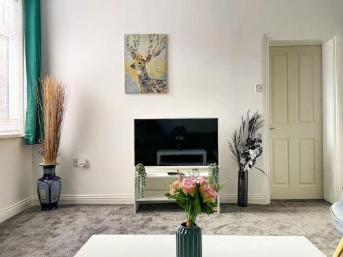 a living room with a vase of flowers on a table at Perfect for Contractors! Free Central Parking! in Birmingham
