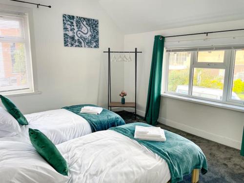 two beds in a room with green curtains at Perfect for Contractors & Families! 7 Beds Free Parking in Birmingham