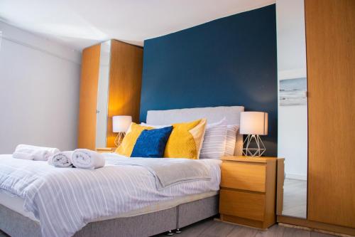een slaapkamer met een groot bed met geel en blauw bij Cozy Flat Reading City Centre Available for Contractors in Reading