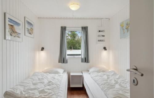 two beds in a room with a window at Cozy Home In Farsø With Sauna in Farsø