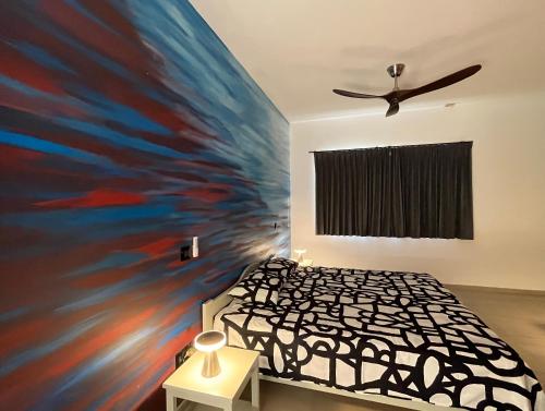 1 dormitorio con 1 cama y una pintura en la pared en Vila Babosa en Porto Novo