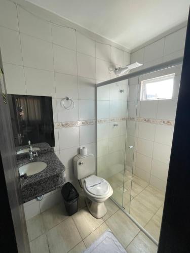 a bathroom with a toilet and a sink and a shower at Shallom Hotel in Balneário Camboriú