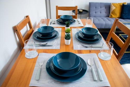 een eettafel met blauwe gerechten erop bij Cozy Flat Reading City Centre Available for Contractors in Reading