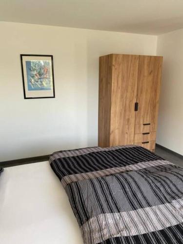 a bedroom with a bed and a wooden cabinet at Ferienwohnung Felina in Passau