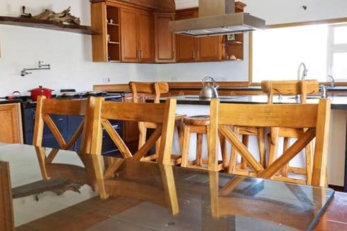 a kitchen with a glass table and wooden chairs at Rinneen in Newtown