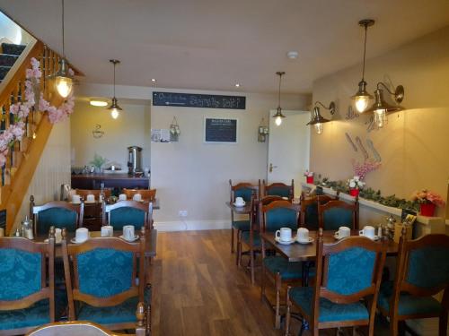 una sala da pranzo con tavoli, sedie e una scala di An Chéibh B&B a Rossaveel