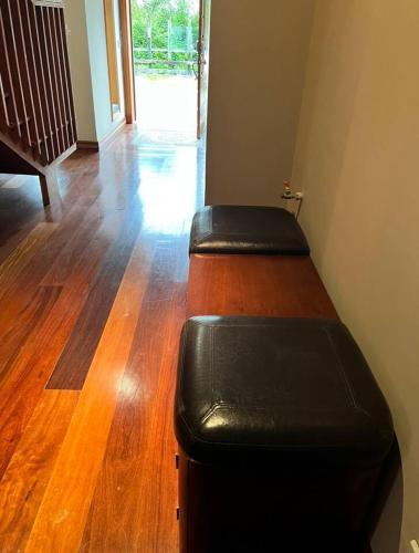 a room with two leather stools on a wooden floor at Rinneen in Newtown