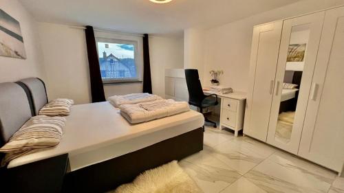 1 dormitorio con cama, escritorio y ventana en Emily’s Apartment en Blaustein