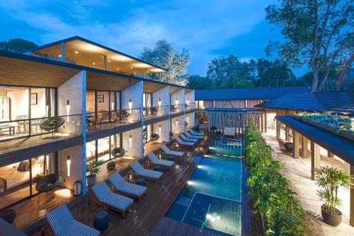 an exterior view of a building with a pool and lounge chairs at El Lugar del que te hable Hotel Boutique in Valle de Bravo
