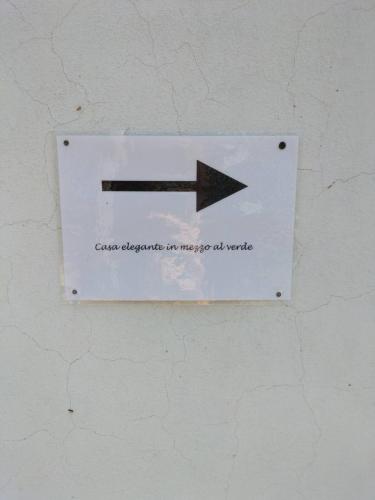 a sign with an arrow on a wall at Casa elegante in mezzo al verde in La Spezia