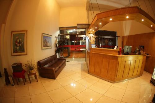 a lobby with a bar and a leather couch at Hotel del Sur in San Lorenzo