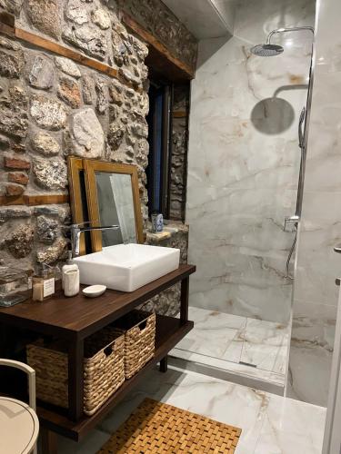 a bathroom with a sink and a mirror at Olympus Stone Lodge in Litochoro