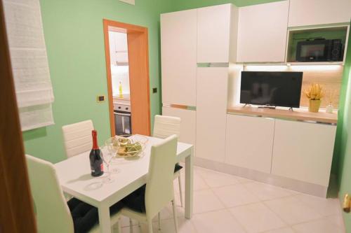 uma cozinha com uma mesa branca e armários brancos em giardini di alabastro em Corato