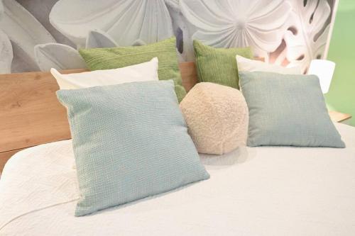 uma cama com almofadas verdes e brancas em giardini di alabastro em Corato