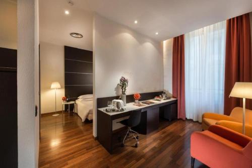 Pokój hotelowy z biurkiem i łóżkiem w obiekcie Grand Hotel Lamezia w mieście Lamezia Terme