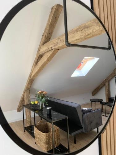 a mirror in a room with a couch and a table at Le Bois Dormans in Dormans