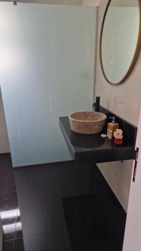 a bathroom with a sink and a mirror on a counter at Vila Henrique Country Cottage in Fajã da Ovelha