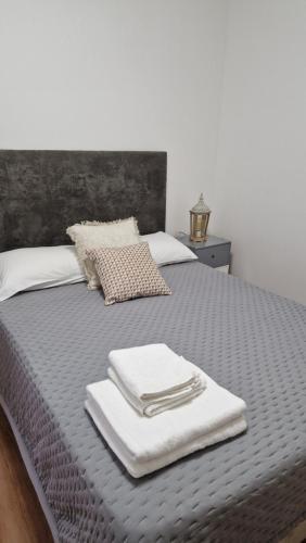 a bed with folded towels on top of it at Vila Henrique Country Cottage in Fajã da Ovelha