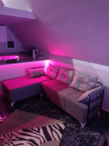 ein Wohnzimmer mit einem Sofa mit rosafarbener Beleuchtung in der Unterkunft Doğayla iç içe huzur dolu deneyim in Muğla