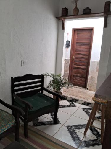 a room with a chair and a table and a door at Espaço Odara Suites com cozinha compatilhada in Paraty