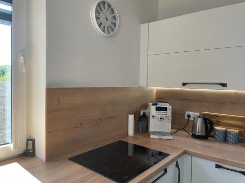 a kitchen with a counter with a coffee maker and a clock at Vila Mima in Nová Lesná