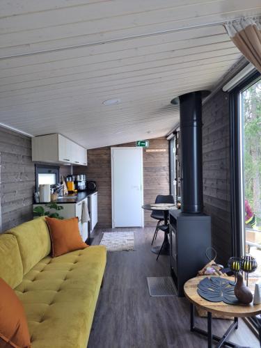 a living room with a couch and a stove at Arctic Circle Beach House in Meltosjärvi