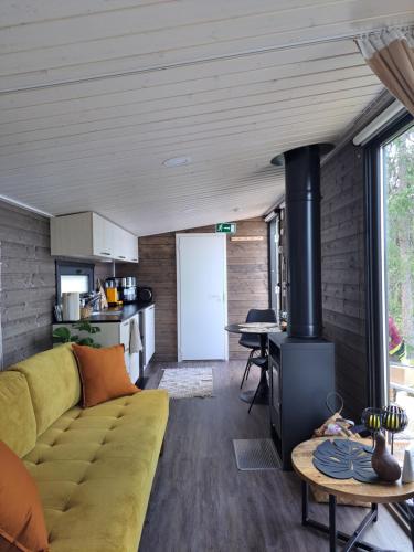 uma sala de estar com um sofá e um fogão em Arctic Circle Beach House em Meltosjärvi