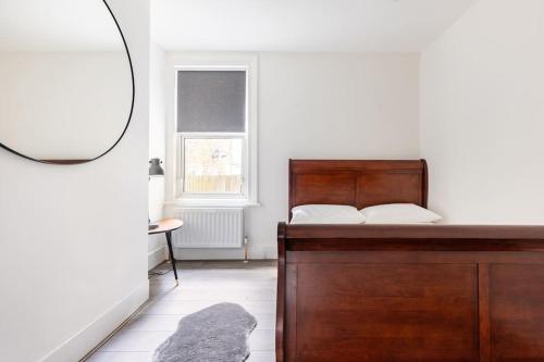 Schlafzimmer mit einem Bett und einem Spiegel in der Unterkunft Gorgeous London Town House Sleeps up to 8 in London