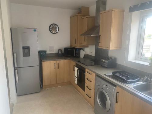 a kitchen with a refrigerator and a washing machine at Contemporary Coach House in Newport, Isle of Wight in Newport