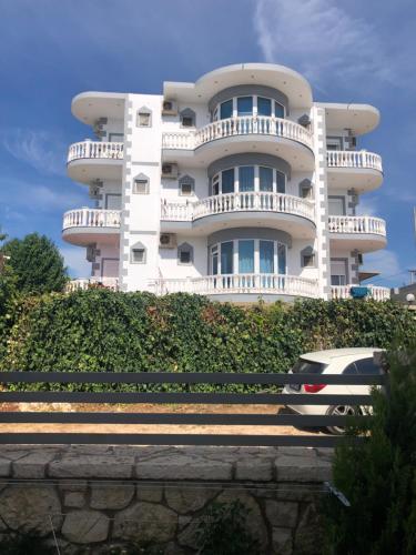 a white building with a car parked in front of it at Studio Apartments Rizarjo in Ksamil