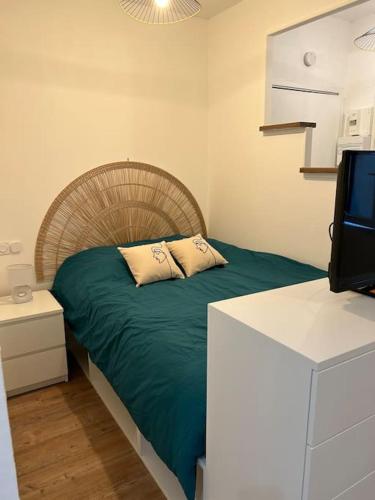 - une chambre avec un lit doté d'une tête de lit en bois et d'une télévision dans l'établissement Au Cœur de Toulouse - Carmes, à Toulouse