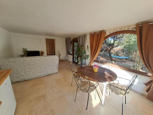 a living room with a table and chairs and a couch at Bas de villa au chant des cigales in Lorgues