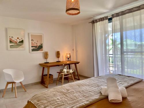 a bedroom with a bed and a table and a window at Appartement duplex Kakoon Saint Martin Anse Marcel in Anse Marcel 