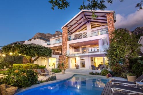 a large house with a swimming pool in front of it at Far Horizons Camps Bay in Cape Town