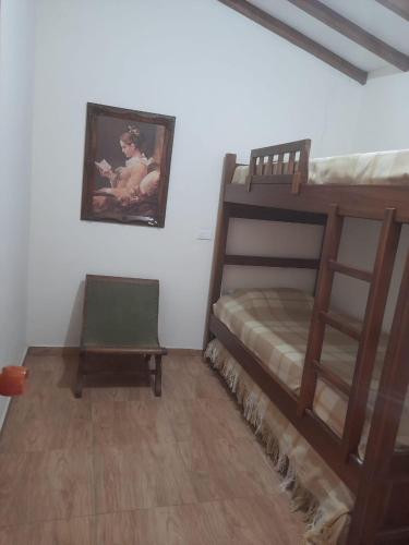 a bedroom with two bunk beds and a chair at Casa Hotel los Patios in Jericó