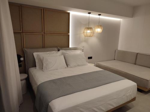 a bedroom with a large bed and a couch at Ammos Paleochora Hotel in Palaiochóra