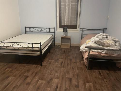 1 Schlafzimmer mit 2 Betten und Holzboden in der Unterkunft Maison de campagne in Champvans