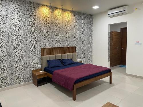 - une chambre avec un lit doté d'un couvre-lit violet dans l'établissement Royal Nest Premium, à Pune