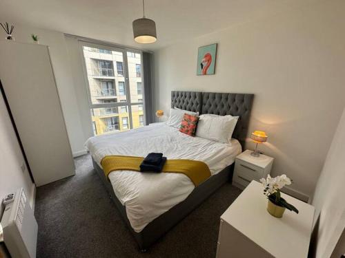a bedroom with a bed with a large window at Beautiful Manchester 2 bedroom apartment in Manchester