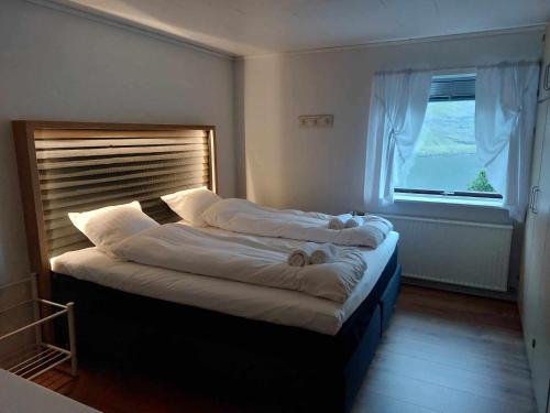 2 camas en una habitación con ventana grande en Fjord Guesthouse en Funningsfjørður