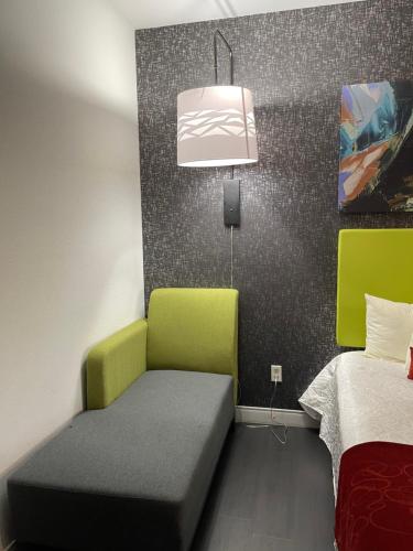 a room with a bed and a couch and a lamp at Lindsay Inn in Lindsay