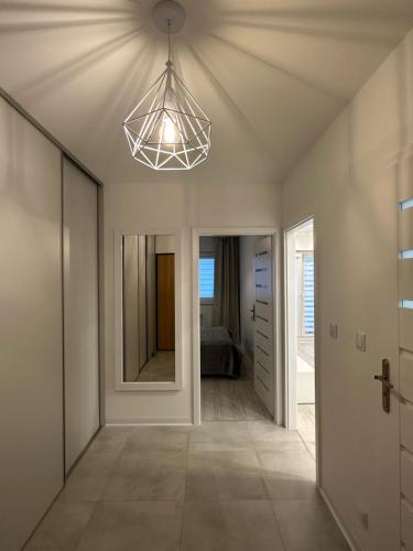 a hallway with a ceiling fan and a mirror at Flat4You III in Poznań