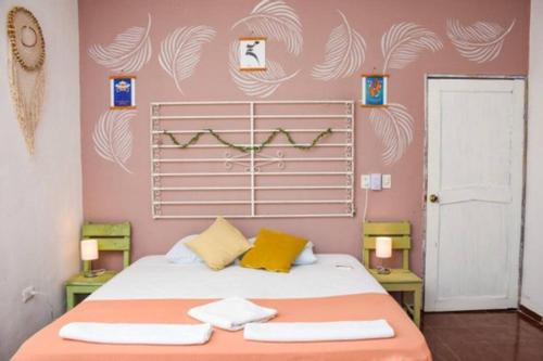 a bedroom with a bed with two towels on it at Departamento cerca del Ferry y del Centro de Holbox in Holbox Island