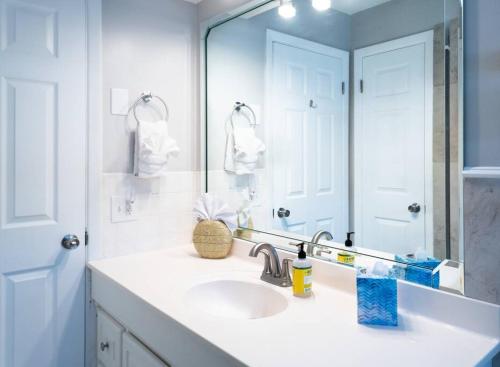 een badkamer met een wastafel en een grote spiegel bij Coral Cottage pool/firepit a 2 bed 2 bth sleeps 6 in Palm Harbor