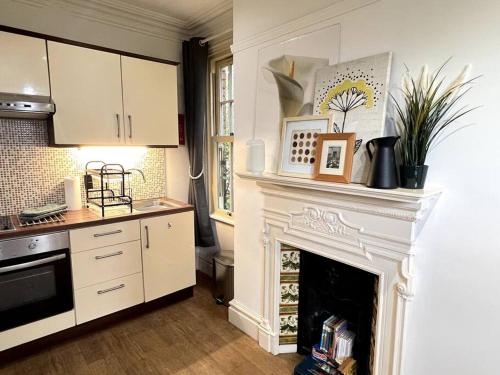 a kitchen with a white fireplace and a stove at The Burley at Scalford House in Melton Mowbray