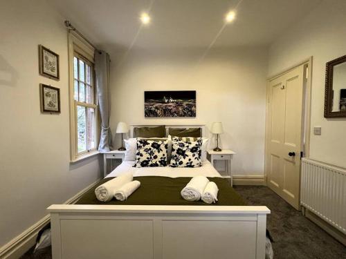 a bedroom with a large bed with pillows at The Burley at Scalford House in Melton Mowbray
