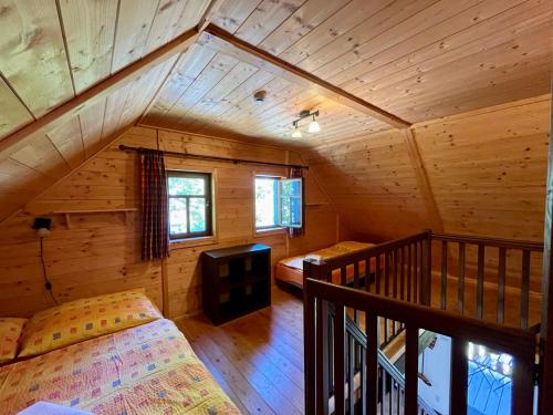 an attic room with a bed and a balcony at Kaproun - Studený pramen in Kunžak